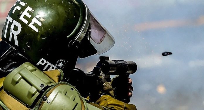 La policía antidisturbios dispara gas lacrimógeno durante una protesta en Santiago. (AFP / MARTIN BERNETTI).