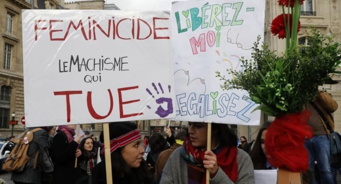 Una mujer sostiene un cartel que dice