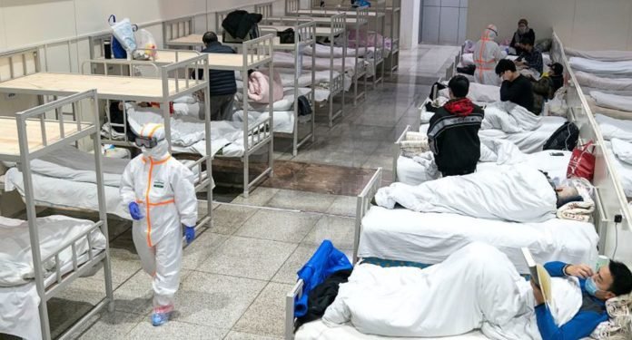 Los trabajadores médicos con trajes protectores atienden a pacientes en el Centro Internacional de Exposiciones y Conferencias de Wuhan, que se ha convertido en un hospital improvisado para recibir pacientes con síntomas leves causados por el nuevo coronavirus, en Wuhan. (Foto: Reuters).