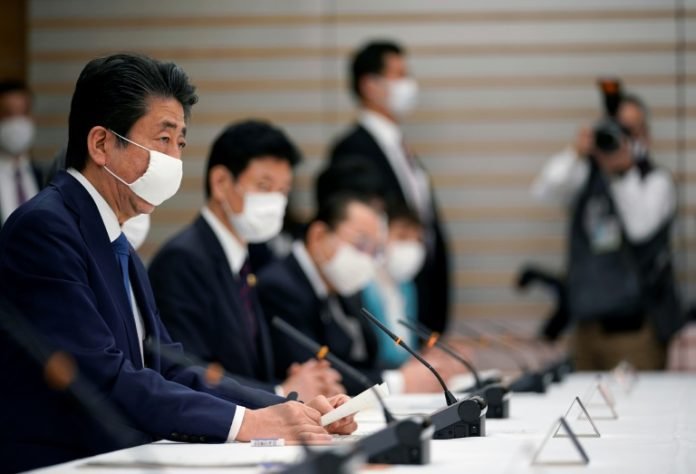 Shinzo Abe (izq) preside una reunión sobre la crisis del coronavirus en la residencia oficial del primer ministro japonés, el 6 de abril de 2020 en Tokio
